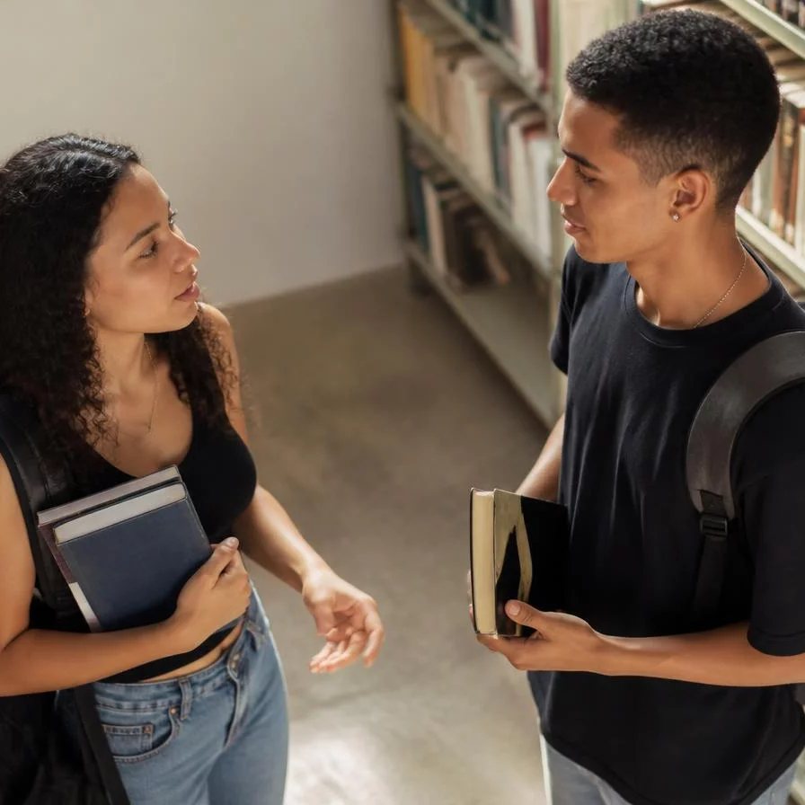 Dois participantes sentados frente a frente durante uma rodada de resposta, na sala da escola em Nova Iguaçu